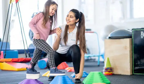 Array of clinical rehabilitation supplies including rolls of kinesiology tape, latex-free resistance bands, and professional massage emollients.